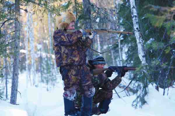 Et par lokale unge fyre på elgjagt for at supplere de sparsomme vinterforsyninger.