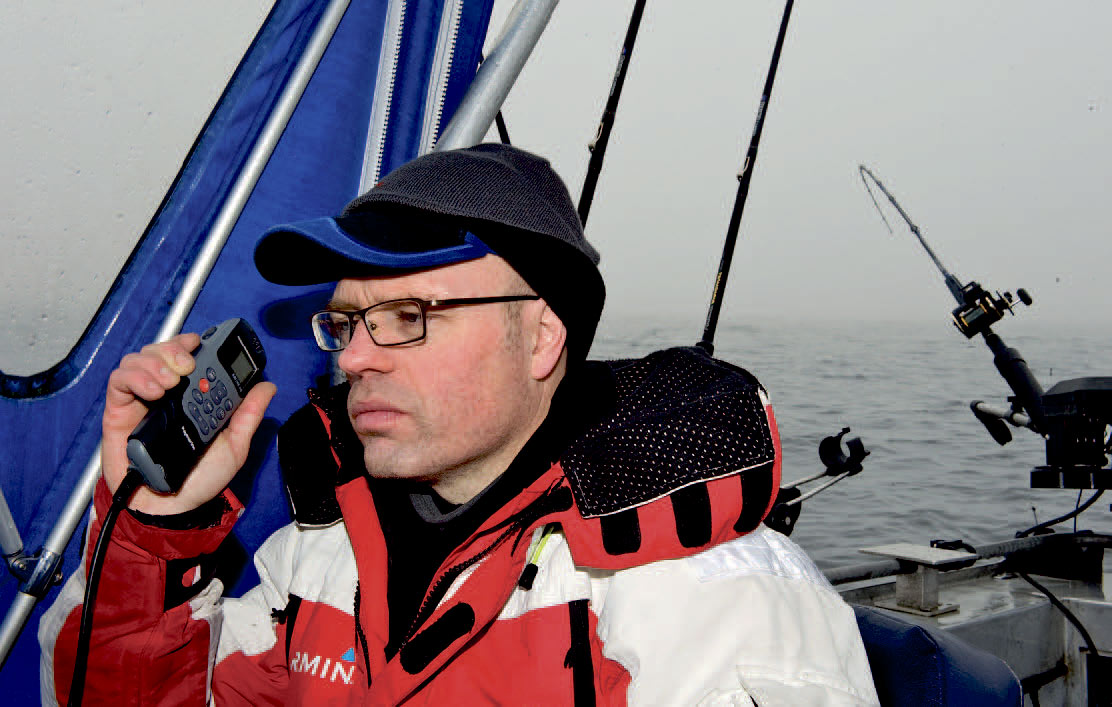 Jan Svenstrup får sig enVHF-sladder med de andre småbåde i området. Ved at hjælpe hinanden er det nemlig lettere at pejle sig ind på, hvor fiskene befinder sig.