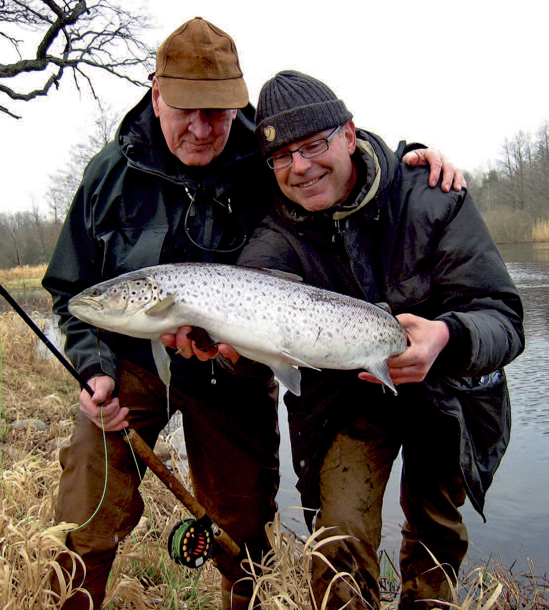 To havørredfiskere med en flot havørred fra Emåen i Sydsverige fanget ved fluefiskeri.