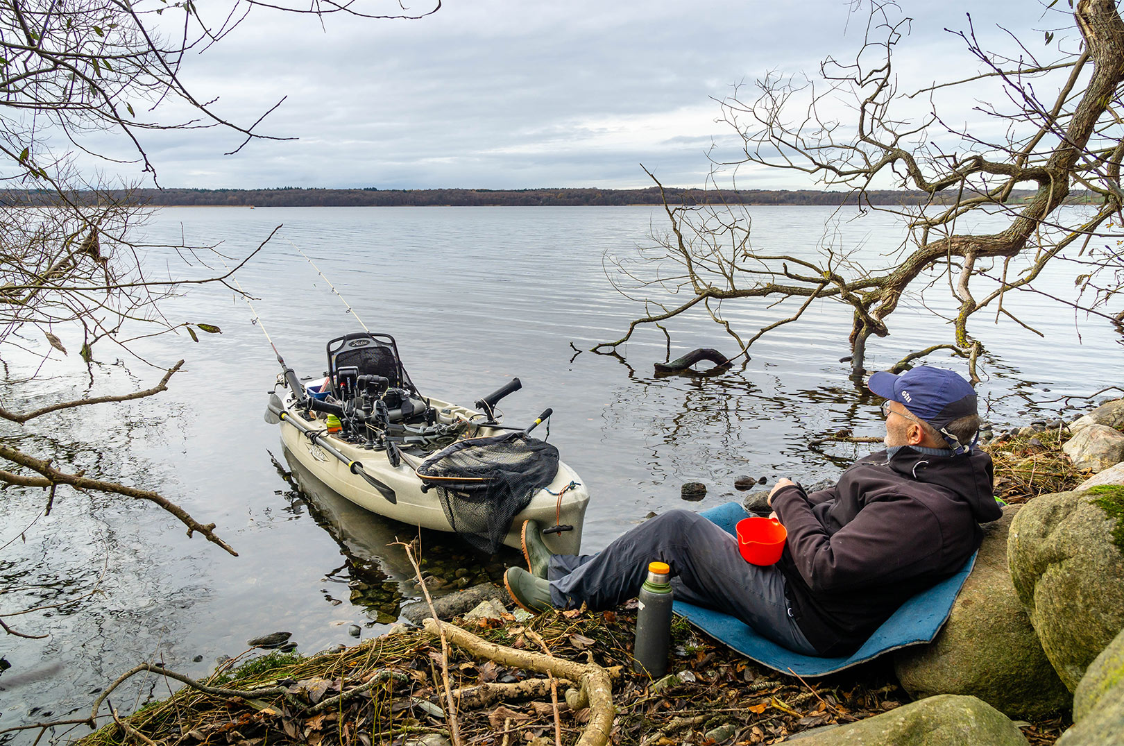 Jan Veiby Jensen tager sig en pause fra kajakfiskeriet ved søens bred - godt tilfreds med sin nye PR-aborre på 1,9 kilo, som du ser ovenfor.