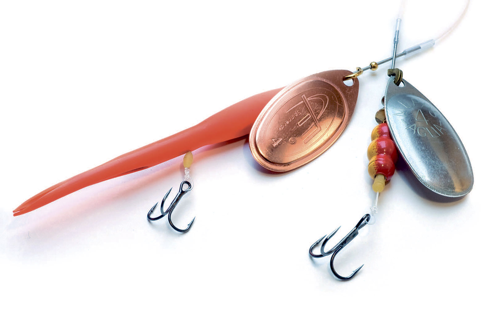 Monteret som gennemløber,kan du fiske både kondom og normale spinnere, så fisken kan afkroges 100% under vand med en disgorger. Til venstre ses FC Kondom med gennemløb, vinkelrig og str. 12 trekrog (Owner ST 36 BC X) – samt th en Mepps 4 med lige gennemløb og str. 8 trekrog. Bemærk flådstoppet – ved at skubbe det frem eller tilbage kan afstanden mellem krog og spinner justeres. Jo mindre krogen er desto længere skal den væk fra spinnerkroppen for at være korrekt eksponeret. Forskyd ikke krogen unødigt langt bagud, da det kan resultere i en dybere krogning.