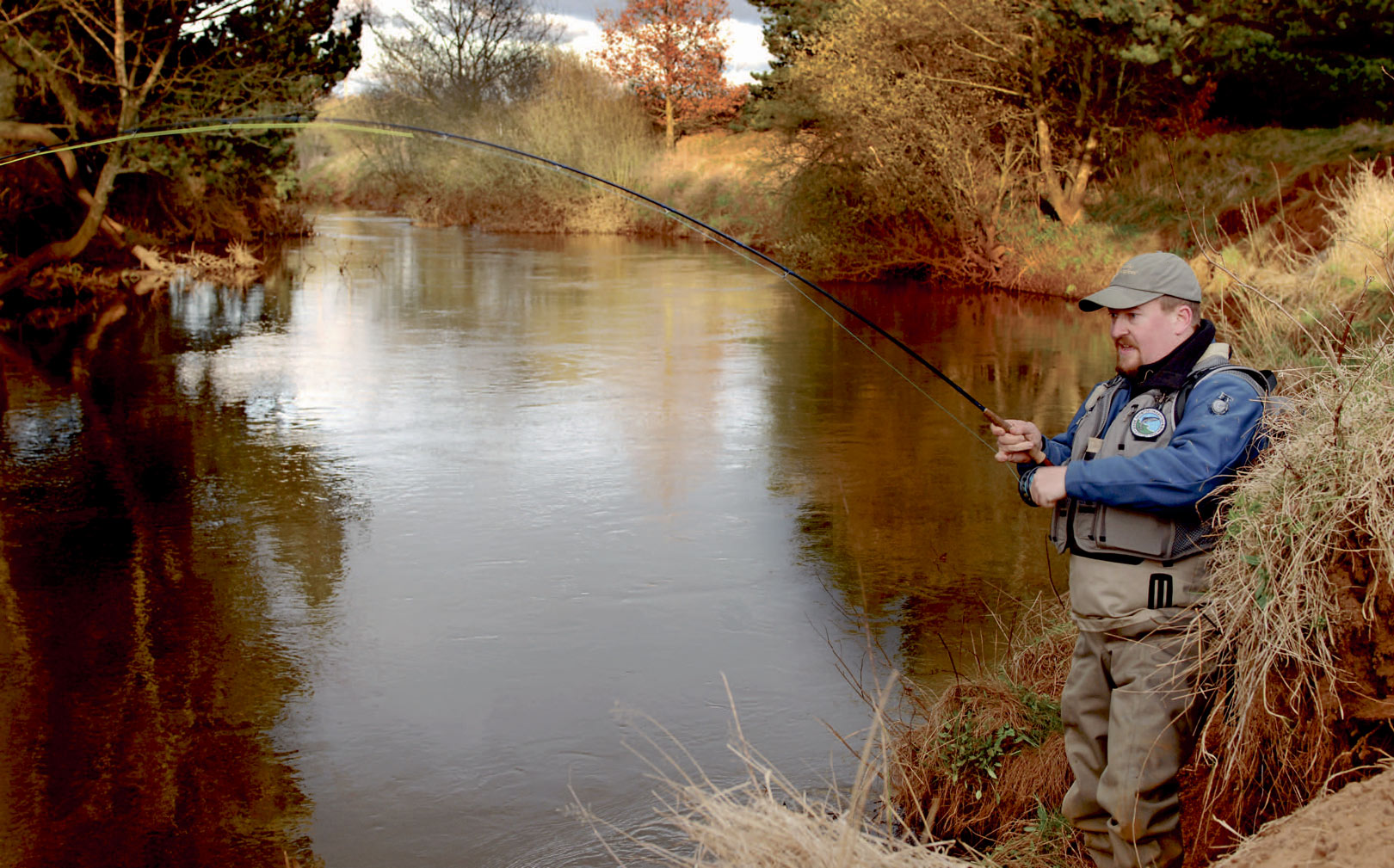 Laksefight i Varde Å, i skovennedstrøms Karlsgårdeværket. Bemærk de høje brinker og mange træer – ideelt fluevand med enhånds stangen.