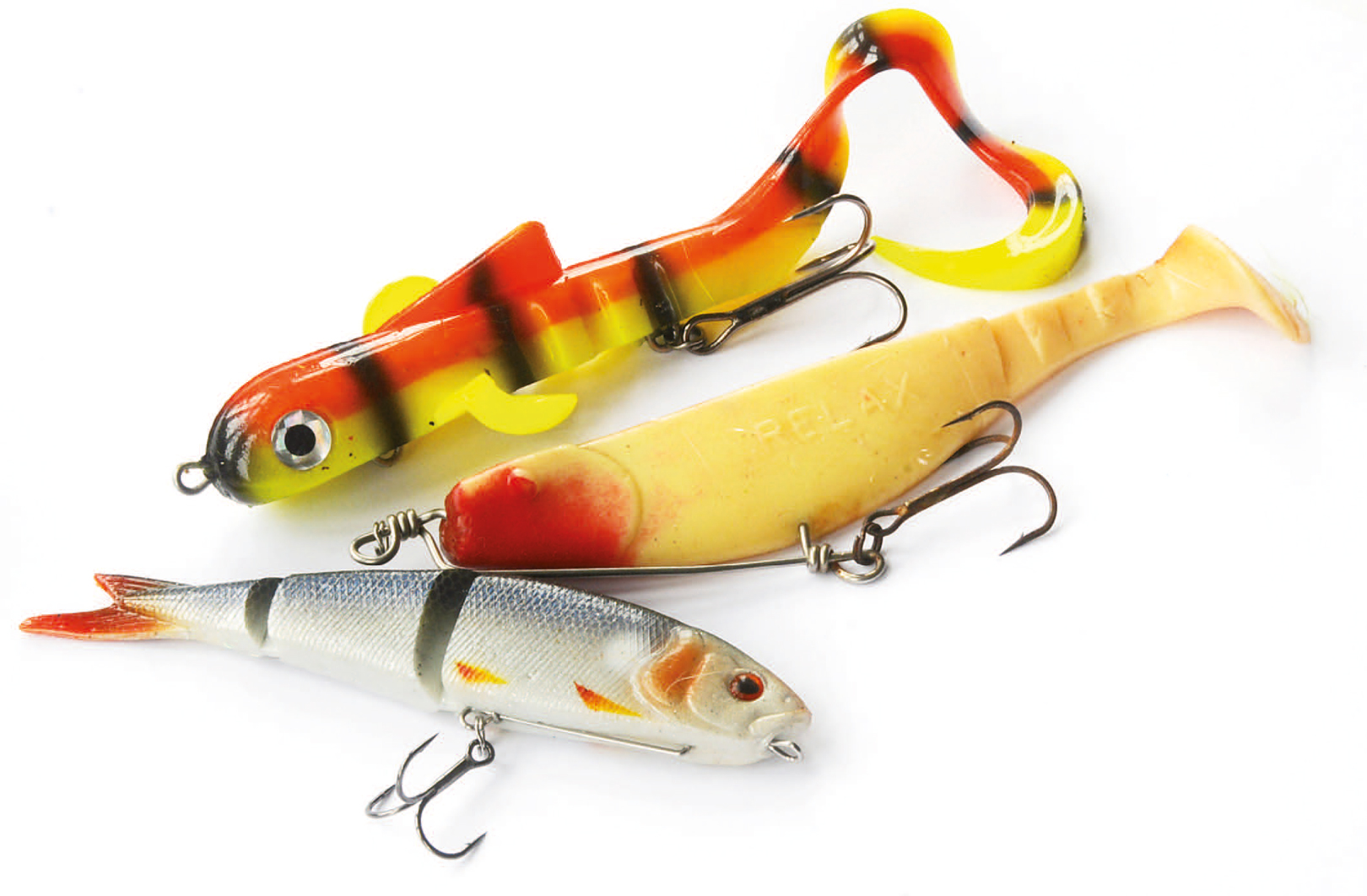 Softbaits eren agntype du virkelig bør eksperimentere med. Gedderne elsker dem simpelthen. Her er det en Alien Eel i den lille version, en Relax shad rigget i et hollænderrig og den nye Soft 4Play fra SavageGear i 13 centimeters versionen.