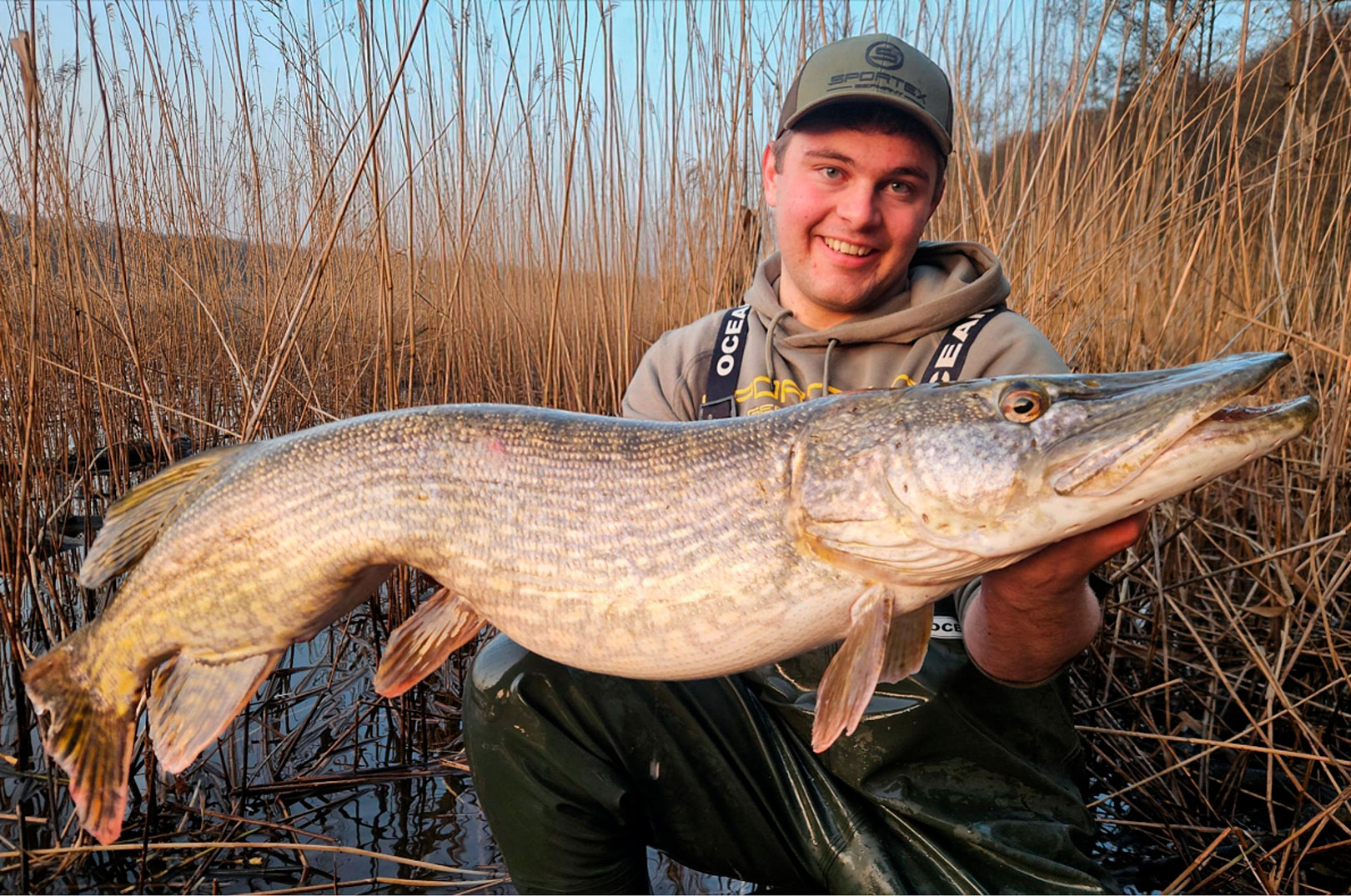 Den mindste af gedderne i det 25 kilo+ tunge dobbelthug ser du her. Øverst Mathe med den største af de to gedder på 14,97 kilo, der kostede en svømmetur i det iskolde vand.