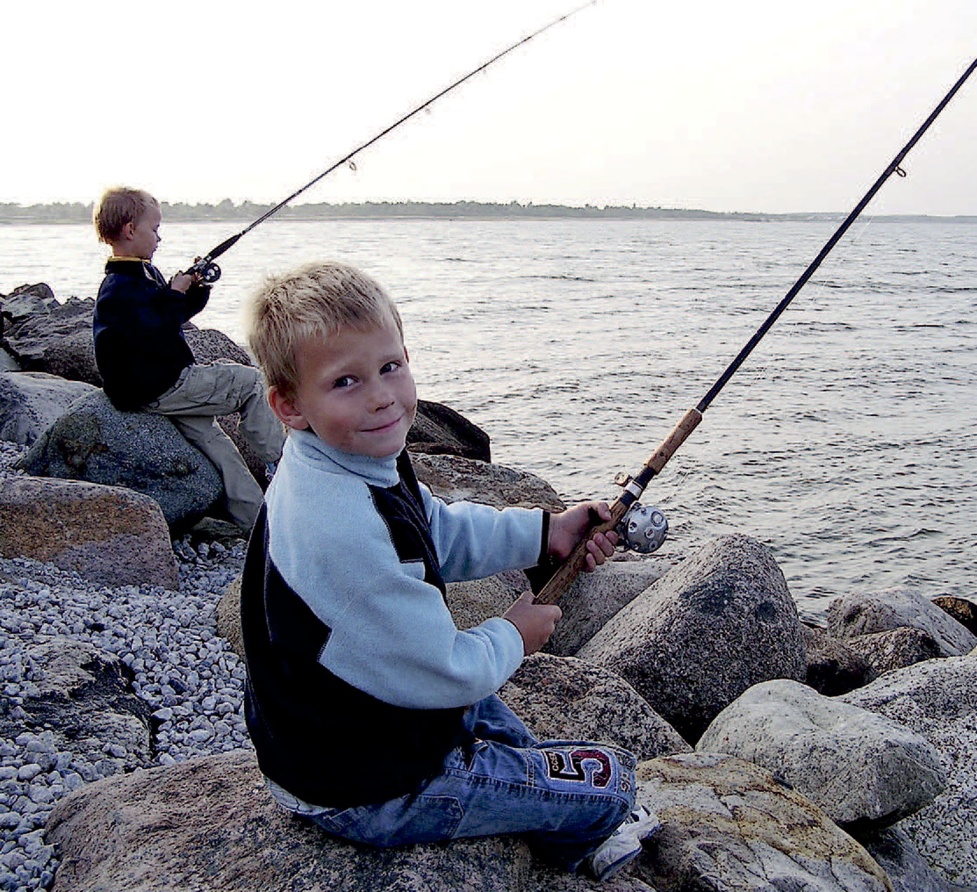 Ungerne nyder at komme medpå fisketur. Men hold rigtig godt øje med dem. De store sten er glatte, og faren kan lure.